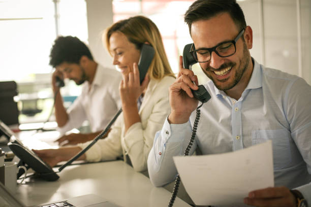 People in operations center  talking on Landline phone. Operators in the office. stock photo