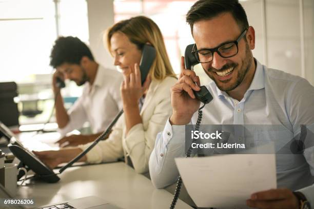 People In Operations Center Talking On Landline Phone Operators In The Office Stock Photo - Download Image Now