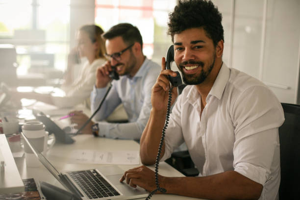 istock People in operations center  talking on Landline phone. Operators in the office. 698026262