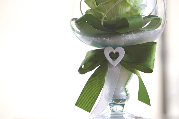 Rose in the crystal Yellow silk rose with green ribbon inside a crystal chalice. Detail. crystal chalice stock pictures, royalty-free photos & images