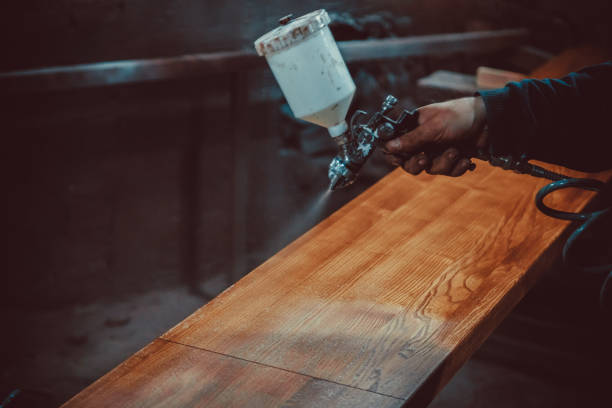 maître peintre dans une usine - bois peinture industrielle avec pistolet à eau. flou artistique. shallow dof. - gas fitter photos photos et images de collection