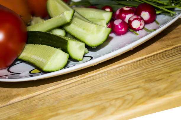 istock Fresh vegetables in a plate - tomatoes, cucumbers, onion, radish on a wooden table 698034462
