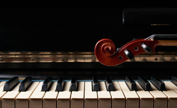 violino a corda musicale classica su tasti del pianoforte. - piano piano key orchestra close up foto e immagini stock