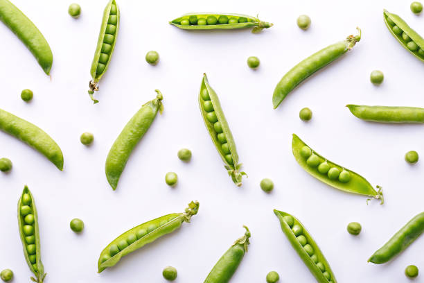 patrón de guisantes. vista superior de verduras frescas sobre un fondo blanco. concepto de repetición - bean pod fotografías e imágenes de stock