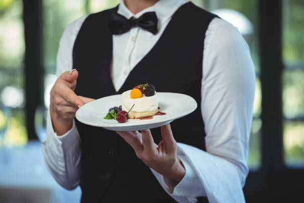 istock Waitress holding a plate with dessert 698051350