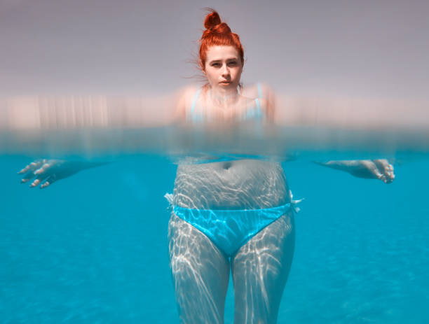 istock woman with distorted body underwater 698055750