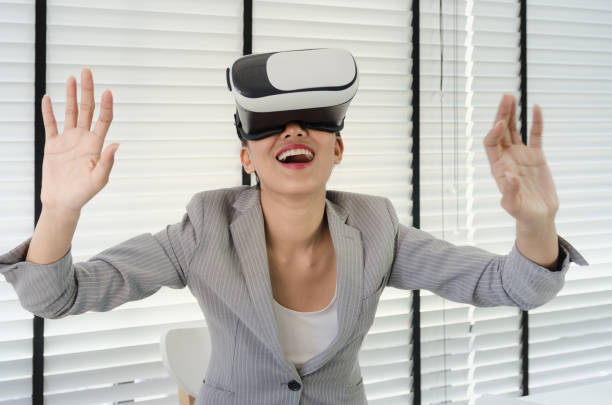 istock Asian woman use virtual reality glasses ( VR ) in her office 698059046