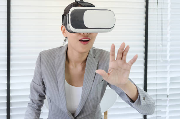 istock Asian woman use virtual reality glasses ( VR ) in her office 698059366