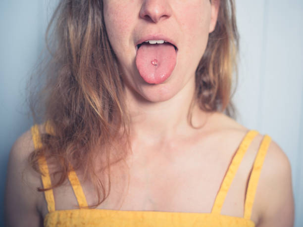A young woman is showing her tongue piercing