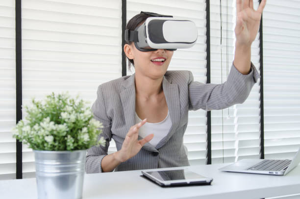 istock Asian woman use virtual reality glasses ( VR ) in her office 698068456