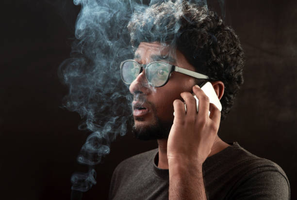 Thoughtful serious face young man with smart phone on his lips walking on stairs.Thinking about news on his phone