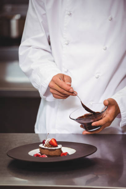 istock Chef putting chocolate sauce on a dessert 698072958