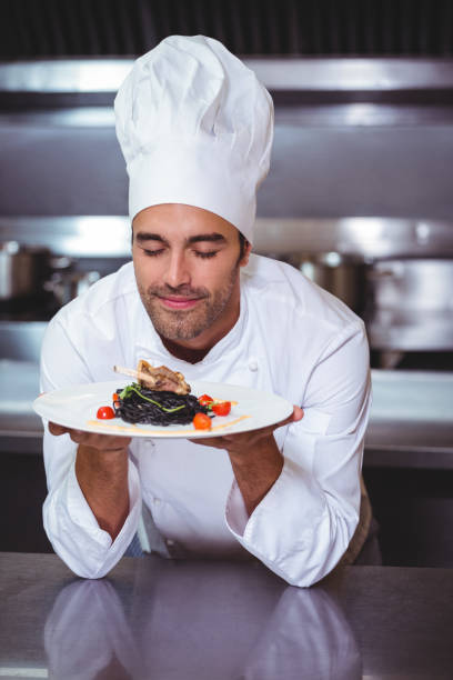 istock Male chef with eyes closed smelling food 698073262