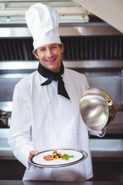 istock Chef raising a bell of a dish 698077078