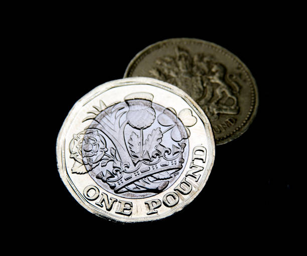 istock New and old one pound coins on black background 698083926