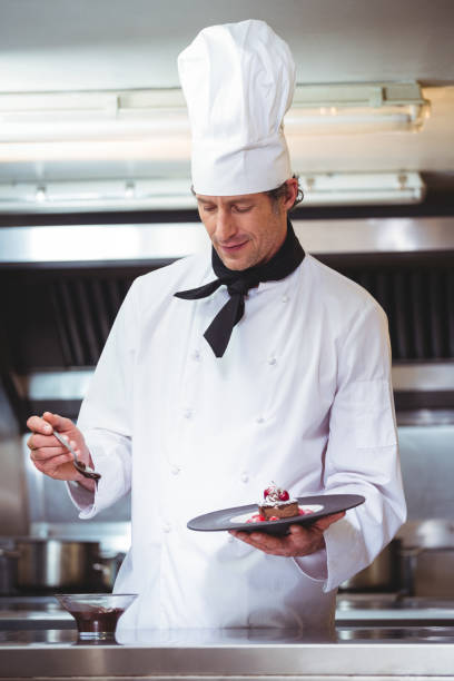istock Chef putting chocolate sauce on a dessert 698094556