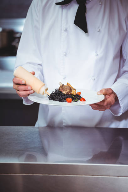 istock Chef putting sauce on a dish of spaghetti 698094950