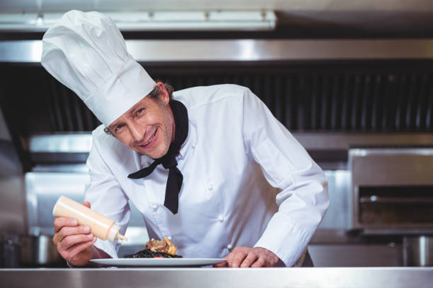 istock Chef putting sauce on a dish of spaghetti 698094992