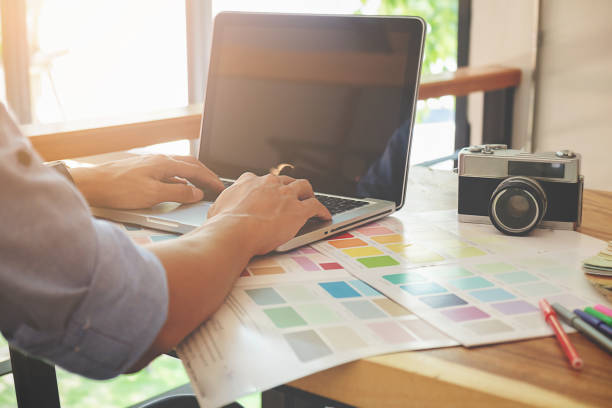 istock Graphic design and color swatches and pens on a desk. Architectural drawing with work tools and accessories. 698095112