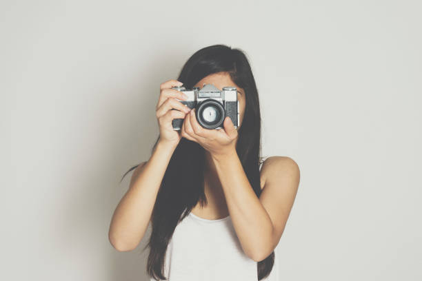 istock Woman take picture with a vintage old camera 698095142