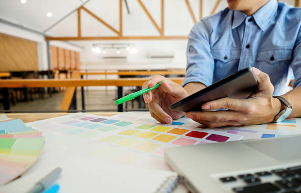 istock Graphic design and color swatches and pens on a desk. Architectural drawing with work tools and accessories. 698095152