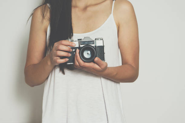 istock Woman holding a vintage camera front a white background 698095580
