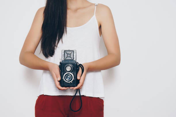 istock Woman holding a vintage camera front a white background 698099790