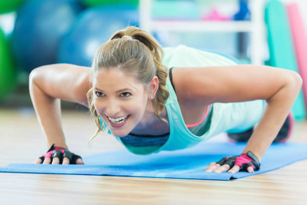 istock Woman smiles as she does pushup on floor mat 698107412