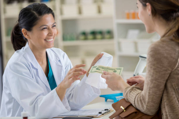 young female pharmacy customer pays for medication - prescription doctor rx pharmacist imagens e fotografias de stock