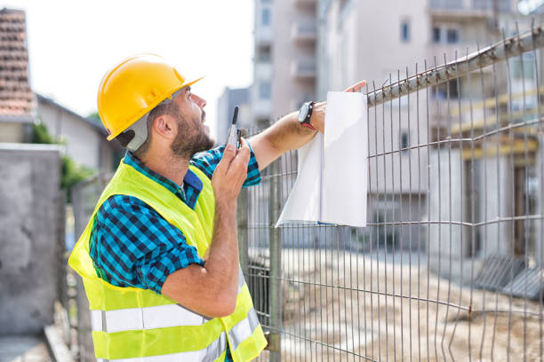 istock Men in hardhat and green jacket posing on building site 698117938