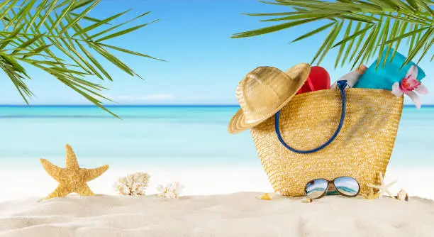 Tropical beach with sunbathing accessories, summer holiday background. Travel and beach vacation, free space for text.