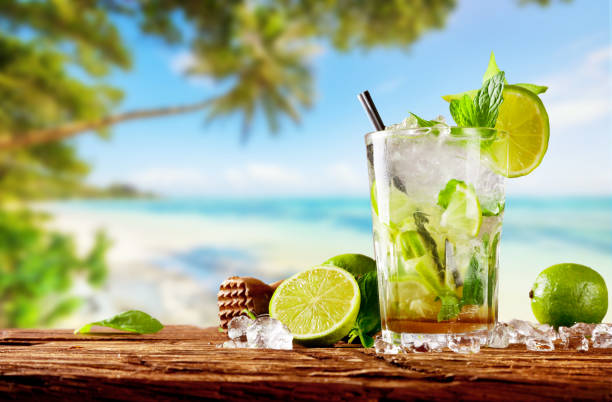 istock Fresh mojito drink placed on wooden planks, blur beach on background 698126352