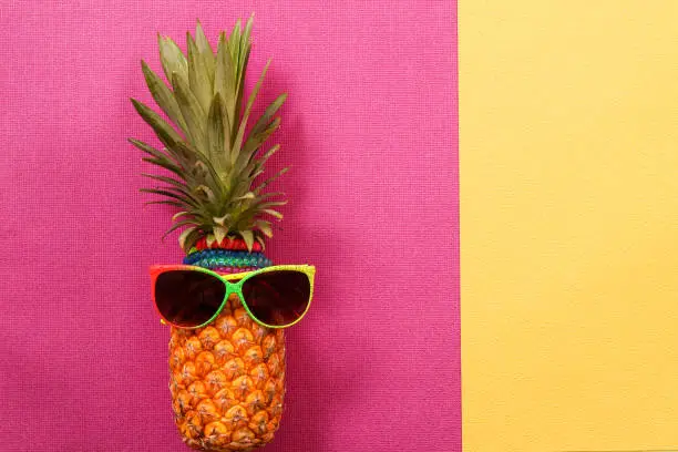 Summer and Holiday concept.Hipster Pineapple Fashion Accessories and Fruits on colorful background