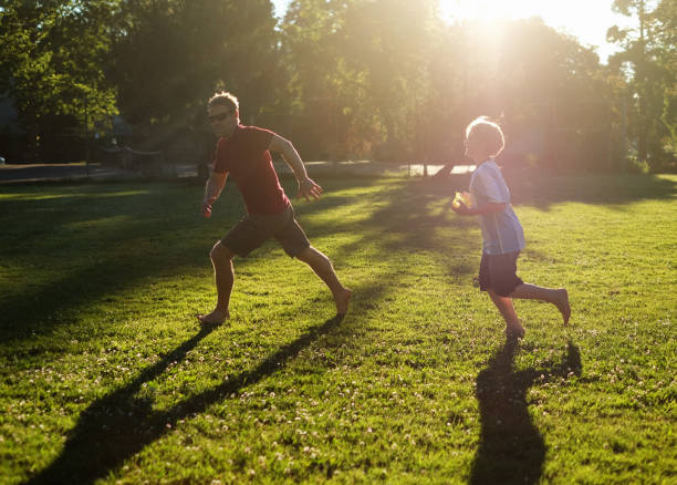 istock Boy chases father with water balloon 698131552