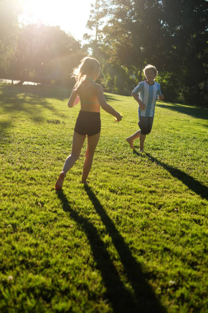 istock Boy and Girl Playing Tag in the Park 698131668