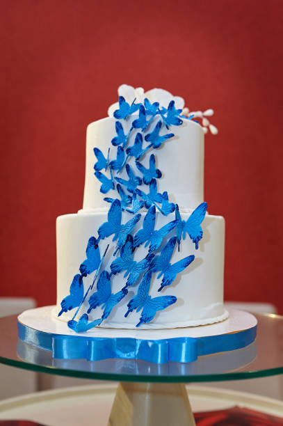istock Two-tier wedding cake with blue butterflies 698137520