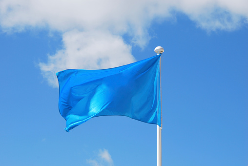 Blue flag waving over the sky. Promotional and advertisement object