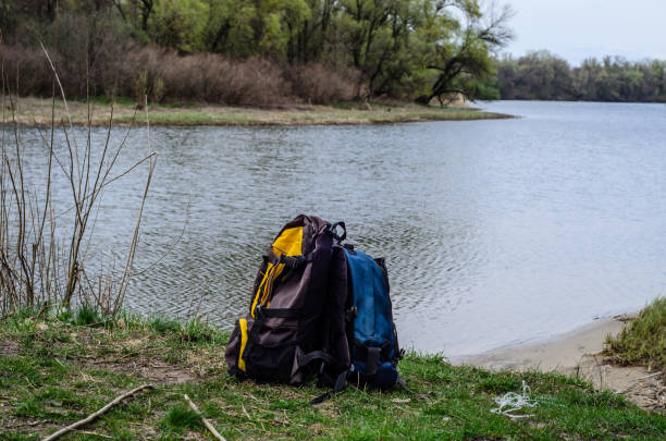 istock Backpacks on a bank of the river 698173436