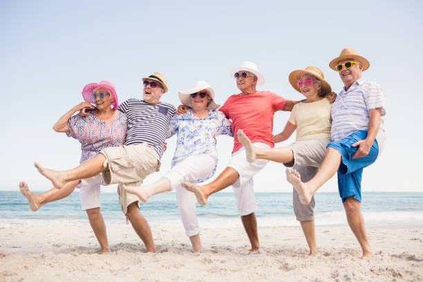 Happy senior friends dancing Happy senior friends dancing on the beach 70 79 years stock pictures, royalty-free photos & images