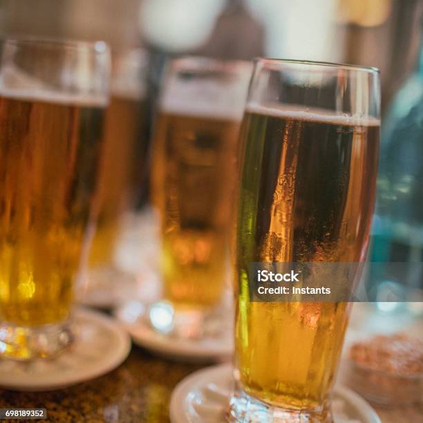 Foto de Quatro Copos De Cerveja Pilsner Em Uma Tabela Como Tiro Em Praga e mais fotos de stock de Bar