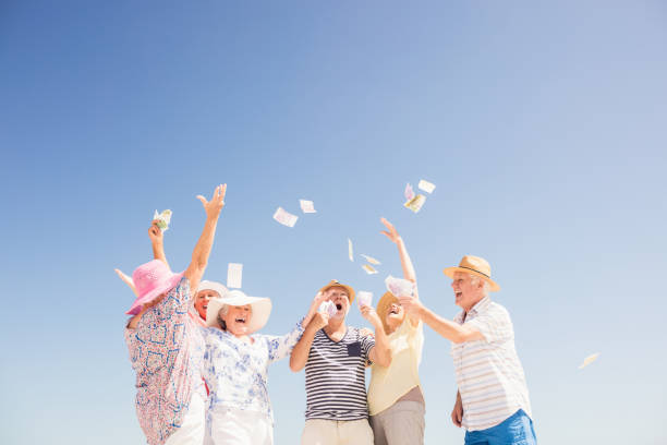 istock Happy senior throwing money 698189630