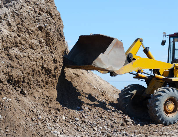 istock Excavator digging  gravel pile for loading in the truck 698189896