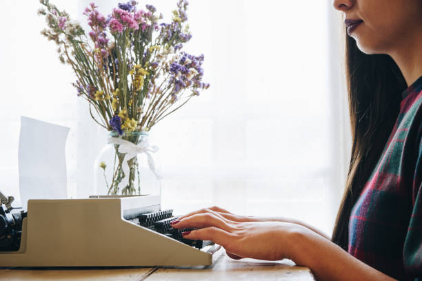 istock Young woman typing on a vintage typewriter 698190300