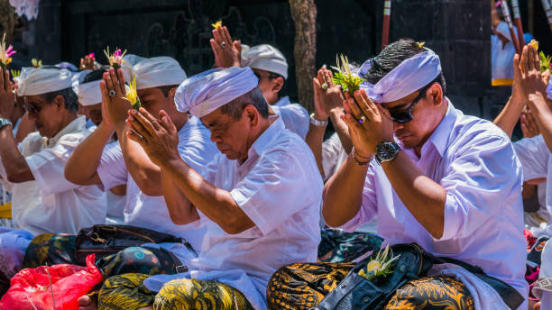 balinés orando en ceremonia en el templo de pura goa lawah, bali, indonesia - pura goa lawah fotografías e imágenes de stock