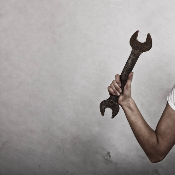 istock Wrench spanner tool in hand of female worker 698205810
