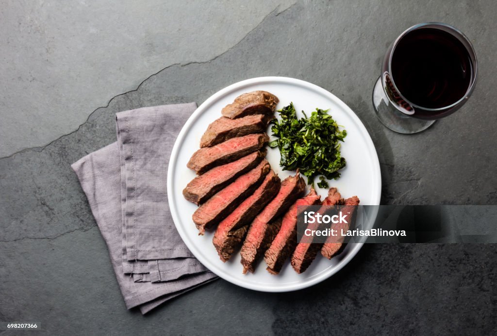 Medio raro bistec servido en plato blanco con vino tinto - Foto de stock de Vista desde arriba libre de derechos