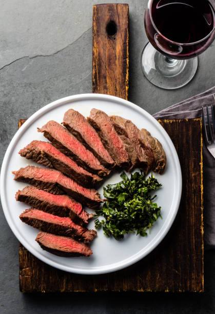 istock Medium rare beef steak served on white plate with red wine 698207626