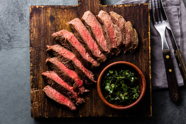 istock Mediun rare beef steak on wooden board. Top view 698211210
