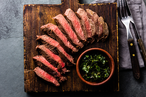 Mediun rare beef steak on wooden board. Top view