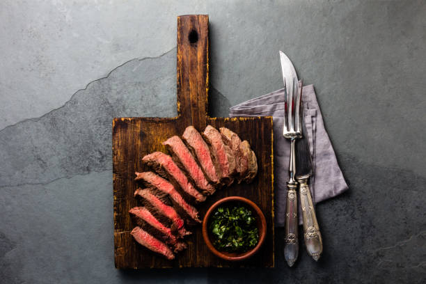 istock Mediun rare beef steak on wooden board. Top view 698211226